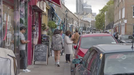 Shops-On-Busy-Street-In-Tower-Hamlets-London-UK-With-Customers