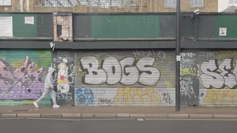 Closed-Shop-Shutters-Spray-Painted-With-Tags-And-Graffiti-in-Tower-Hamlets-London-In-UK-1