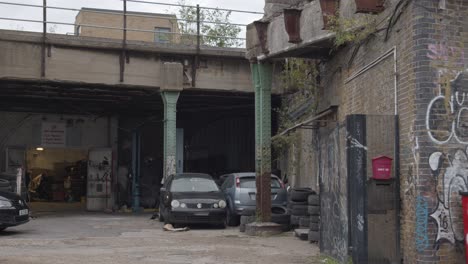 Car-Garage-In-Inner-City-London-With-Graffiti-Covered-Walls-And-Security-Fencing-In-London-UK