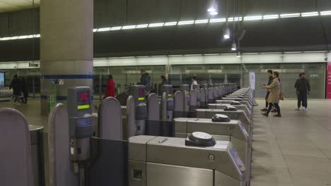 Passengers-At-Ticket-Barrier-At-Canary-Wharf-Underground-Station-Docklands-London-UK