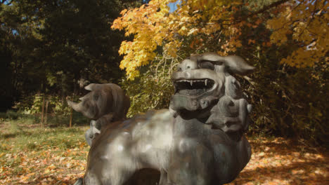 Sculpture-Of-Chinese-Dragon-Dog-In-Arboretum-With-Colourful-Autumn-Trees-In-Background-1