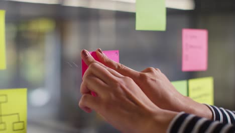 Close-Up-Of-Woman-Putting-Sticky-Note-With-Trends-Written-On-It-Onto-Transparent-Screen-In-Office-2