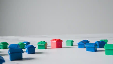 Eigenheimkaufkonzept-Mit-Entwicklung-Eines-Roten,-Blauen-Und-Grünen-Plastikmodells-Von-Häusern-Auf-Weißem-Hintergrund-1
