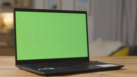 Laptop-Mit-Grünem-Bildschirm-Auf-Dem-Tisch-Zu-Hause