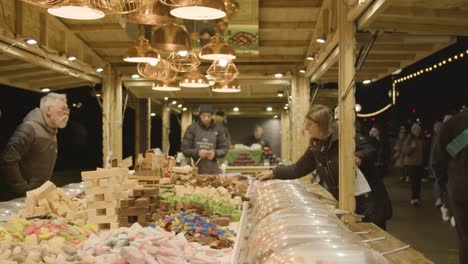 Close-Up-Customers-At-Stall-Selling-Candy-At-Christmas-Market-On-London-South-Bank-At-Night-1
