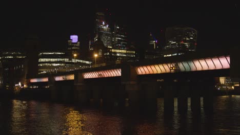 Vistas-Al-Río-Támesis-Mirando-Hacia-La-Ciudad-De-Londres-Con-Puente-Iluminado-Por-La-Noche
