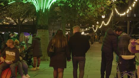 Menschen,-Die-Bei-Nacht-An-Weihnachtlich-Beleuchteten-Bäumen-Am-Südufer-In-London-Vorbeigehen-4