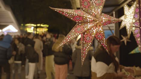 Close-Up-Stall-Selling-Star-Shaped-Lights-Or-Decorations-At-Christmas-Market-On-London-South-Bank-At-Night