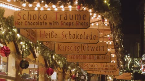 Schilder-An-Essens--Und-Getränkeständen-Auf-Dem-Frankfurter-Weihnachtsmarkt-In-Birmingham,-Großbritannien-Bei-Nacht