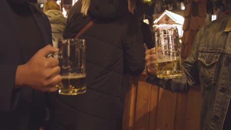Nahaufnahme-Von-Leuten,-Die-Nachts-Bier-An-Den-Frankfurter-Weihnachtsmarktständen-In-Birmingham-Uk-Trinken