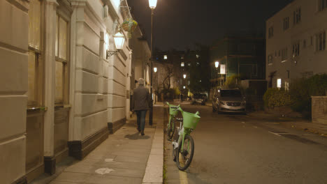 Man-Walking-Past-Exclusive-Luxury-Housing-In-Belgravia-London-At-Night