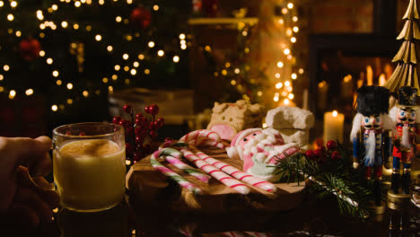 Weihnachten-Zu-Hause-Mit-Person,-Die-Ein-Glas-Eierlikörzuckerstangen-Und-Kekse-Trinkt