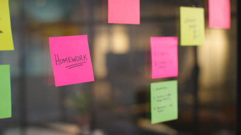 Close-Up-Of-Woman-Putting-Sticky-Note-With-Homework-Written-On-It-Onto-Transparent-Screen-In-Office-1