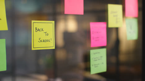 Close-Up-Of-Woman-Putting-Sticky-Note-With-Back-To-School-Written-On-It-Onto-Transparent-Screen-In-Office-1