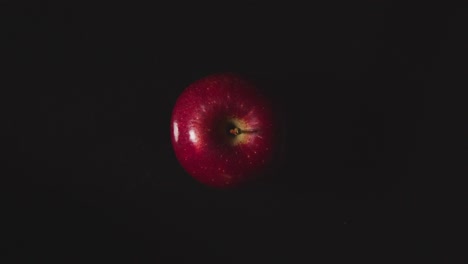 Obenliegende-Studioaufnahme-Des-Roten-Apfels,-Der-Sich-Vor-Schwarzem-Hintergrund-Dreht