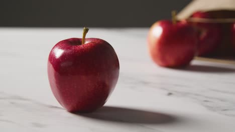 Studio-Shot-Of-Paper-Bag-Of-Red-Apples-On-Marble-Kitchen-Surface-1