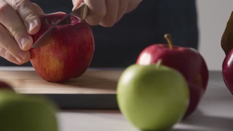 Close-Up-Of-Man-Cutting-Fresh-Apples-On-Chopping-Board-4