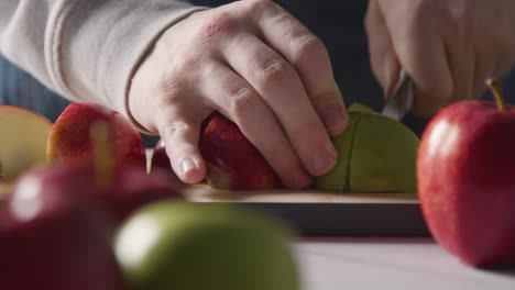 Close-Up-Of-Man-Cutting-Fresh-Apples-On-Chopping-Board-6