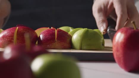 Close-Up-Of-Man-Carrying-Chopping-Board-With-Sliced-Read-And-Green-Apples
