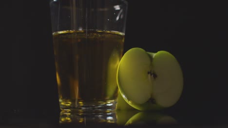 Studio-Shot-Of-Glass-Of-Apple-Juice-With-Sliced-Fresh-Apples-On-Black-Background