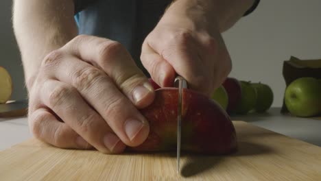 Close-Up-Of-Man-Cutting-Fresh-Apples-On-Chopping-Board-1
