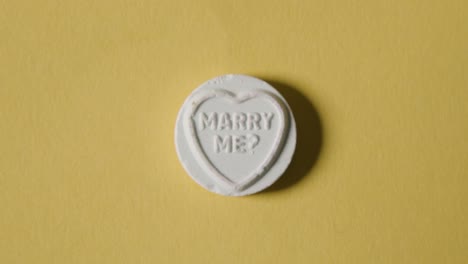 Heart-Candy-With-Marry-Me-Message-On-Yellow-Background