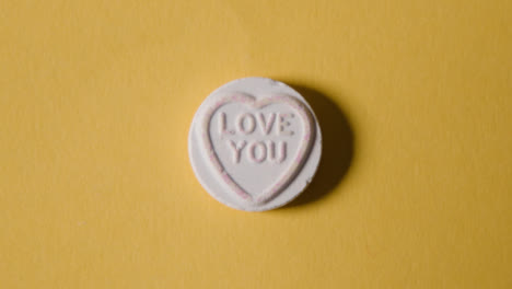 Caramelo-De-Corazón-Con-Mensaje-De-Amor-Sobre-Fondo-Amarillo