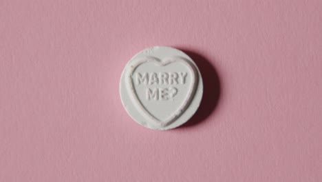 Heart-Candy-With-Marry-Me-Message-On-Pink-Background