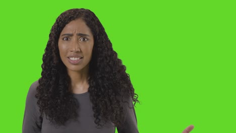 Portrait-Of-Angry-Looking-Woman-Shouting-At-Camera-Against-Green-Screen