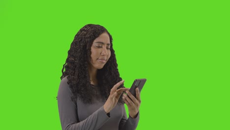 Woman-Waiting-Looking-At-Mobile-Phone-Against-Green-Screen