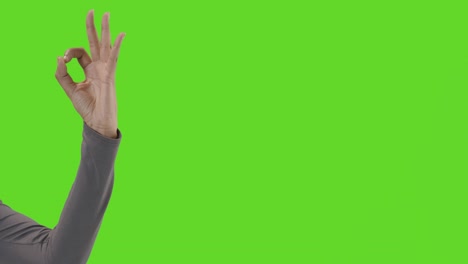 Studio-Close-Up-Shot-Of-Woman-Giving-OK-Sign-Against-Green-Screen
