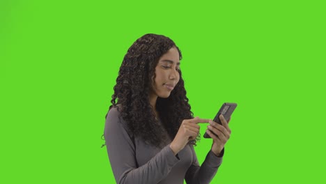 Woman-Looking-At-Mobile-Phone-And-Celebrating-Good-News-Against-Green-Screen-2