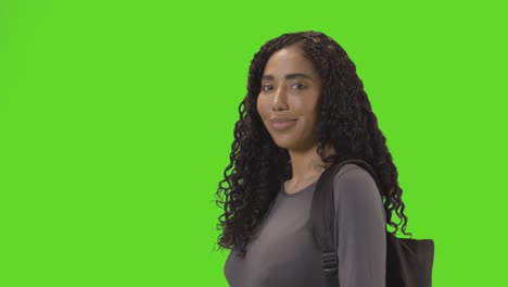 Portrait-Of-Female-College-Or-University-Student-Against-Green-Screen-Smiling-At-Camera-1
