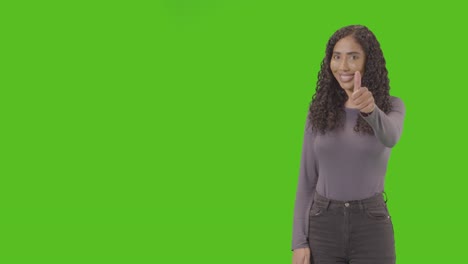 Studio-Three-Quarter-Length-Shot-Of-Woman-Giving-Thumbs-Up-Sign-Against-Green-Screen-1