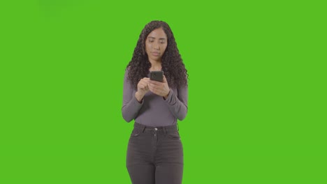 Woman-Looking-At-Mobile-Phone-And-Celebrating-Good-News-Against-Green-Screen-4