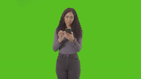 Woman-Looking-At-Mobile-Phone-And-Celebrating-Good-News-Against-Green-Screen-5
