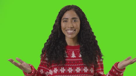 Studio-Portrait-Of-Woman-Wearing-Christmas-Jumper-Against-Green-Screen-Smiling-At-Camera-Saying-Merry-Christmas-2