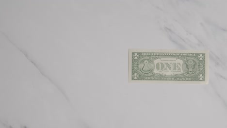 Overhead-Currency-Shot-Of-Hand-Grabbing-US-1-Dollar-Bill-On-Marble-Surface-1