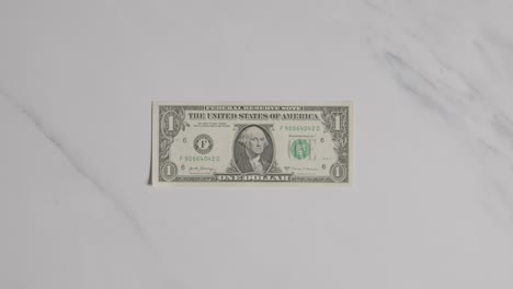 Overhead-Currency-Shot-Of-Hand-Grabbing-US-1-Dollar-Bill-On-Marble-Surface-2