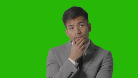 Portrait-Of-Serious-Businessman-In-Suit-Thinking-Against-Green-Screen-Having-Idea