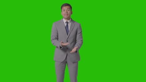 Three-Quarter-Length-Shot-Of-Angry-Businessman-In-Suit-Against-Green-Screen-Talking-To-Camera