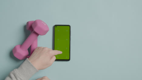 Overhead-Fitness-Studio-Shot-Of-Exercise-Dumbbell-Weights-With-Hand-Using-Green-Screen-Mobile-Phone-2