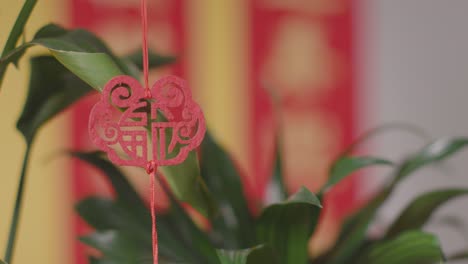 Close-Up-Of-Decoration-Celebrating-Chinese-New-Year-Hanging-On-Plant-At-Home-