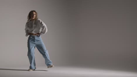 Full-Length-Studio-Shot-Of-Young-Woman-Having-Fun-Dancing-Against-Grey-Background