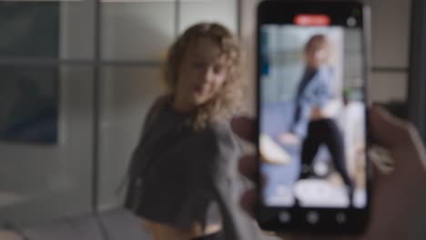 Person-Recording-Social-Media-Video-On-Mobile-Phone-Of-Woman-Dancing-At-Home-1