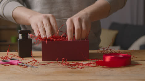 Close-Up-Of-Man-At-Home-Gift-Wrapping-Romantic-Valentines-Present-In-Box-1