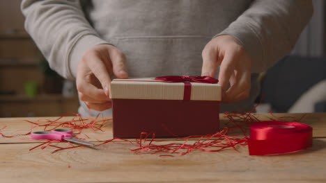 Close-Up-Of-Man-At-Home-Gift-Wrapping-Romantic-Valentines-Present-In-Box-2