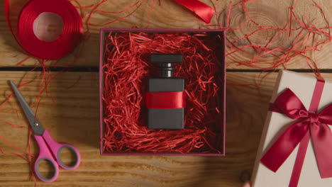 Overhead-Shot-Of-Man-Gift-Wrapping-Romantic-Valentines-Present-Of-Perfume-In-Box-On-Table-1