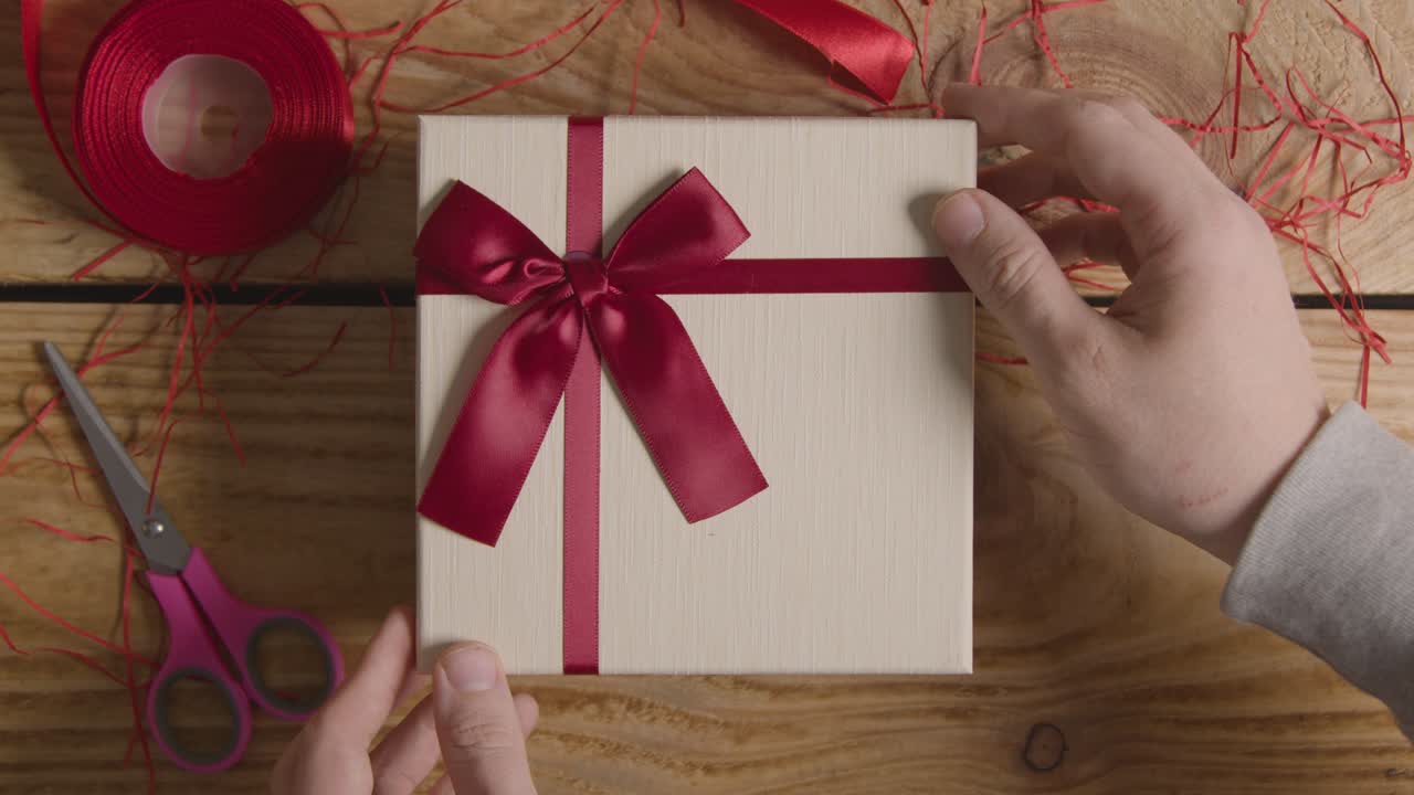 Free stock video Overhead shot of man gift wrapping romantic