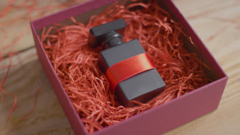 Close-Up-Shot-Of-Romantic-Valentines-Present-Of-Perfume-Gift-Wrapped-In-Box-On-Table-1